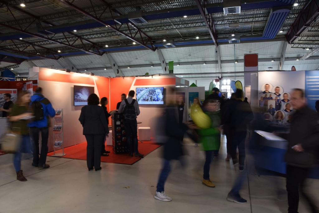 People walking in a busy education exhibition hall and having conversations